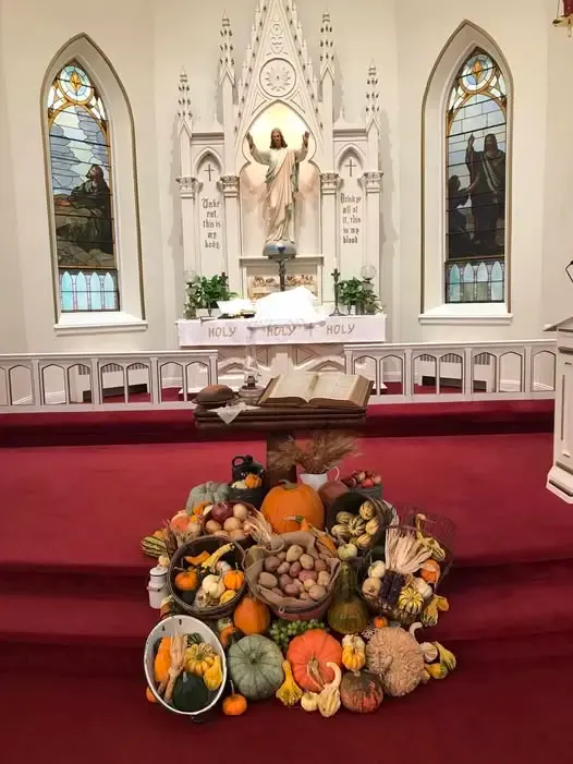 The white gothic altar of the 1884 Trinity church decorated with a harvest of pumpkins and gourds
