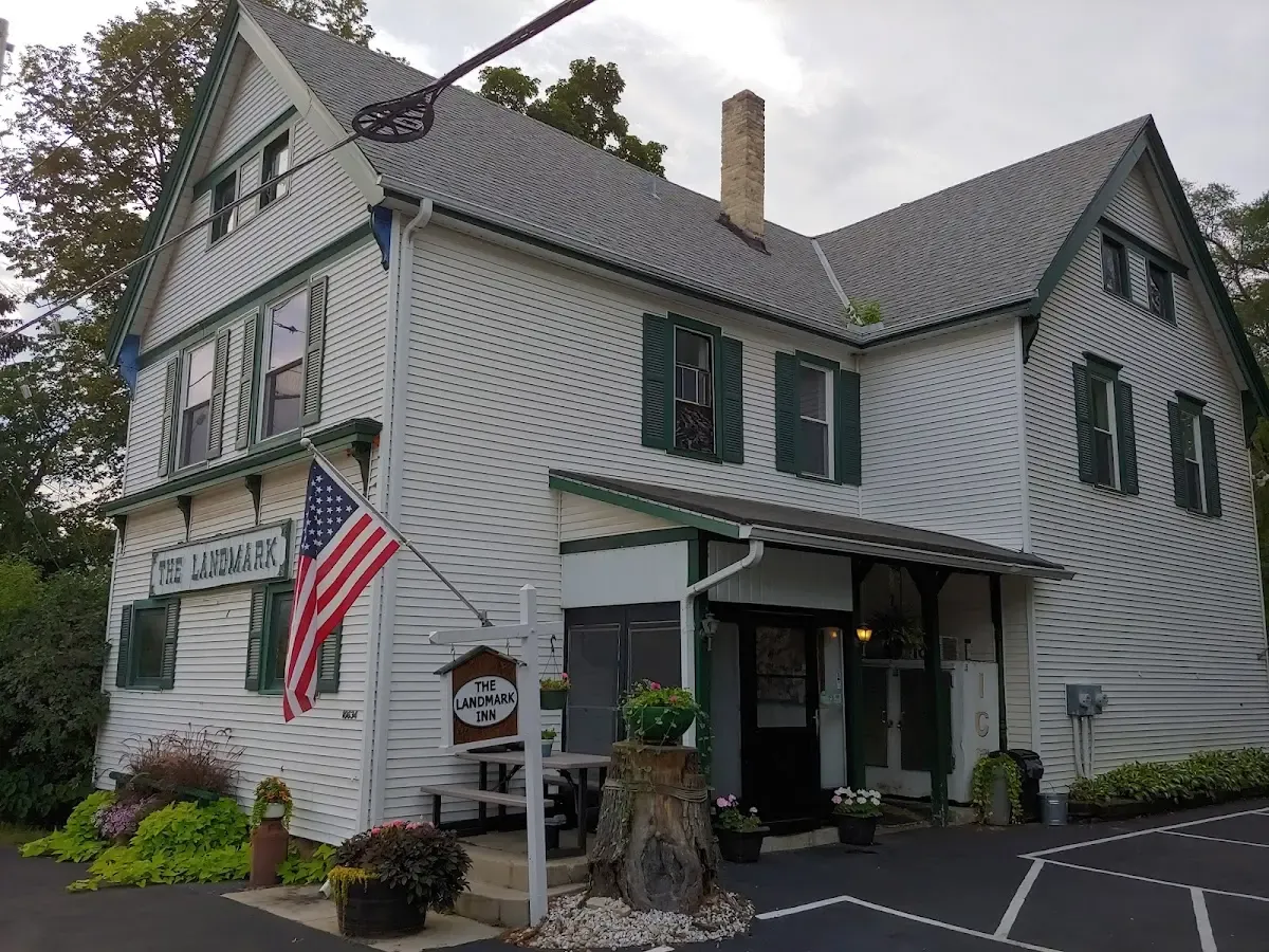 The Landmark restaurant — a two-story white clapboard building with green shutters and an American flag over the porch